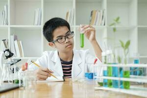 Jeune scientifiques dans action des gamins conduite chimie expérience dans école laboratoire photo
