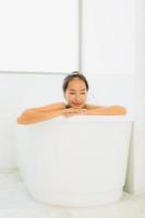 Portrait belle jeune femme asiatique prendre une baignoire dans la salle de bain photo