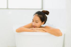 Portrait belle jeune femme asiatique prendre une baignoire dans la salle de bain photo