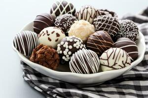 sombre, Lait et blanc Chocolat des sucreries, truffes, assorti sur en bois tableau. dessert pour la Saint-Valentin journée. photo