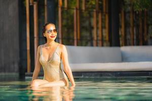 Portrait jeune belle femme asiatique sourire heureux et se détendre dans la piscine autour de l'hôtel resort photo