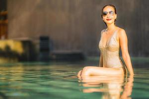 Portrait jeune belle femme asiatique sourire heureux et se détendre dans la piscine autour de l'hôtel resort photo