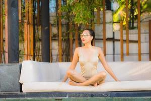 Portrait jeune belle femme asiatique sourire heureux et se détendre dans la piscine autour de l'hôtel resort photo