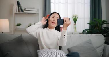 asiatique femme en jouant une Jeu sur téléphone intelligent photo