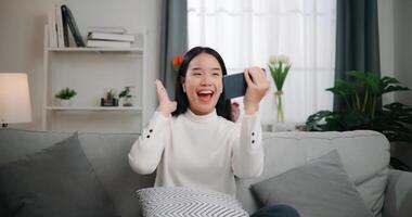 asiatique femme en jouant une Jeu sur téléphone intelligent photo