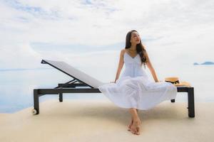 Portrait jeune femme asiatique se détendre sourire heureux autour de la piscine de l'hôtel et du complexe photo