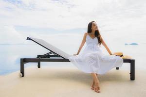 Portrait jeune femme asiatique se détendre sourire heureux autour de la piscine de l'hôtel et du complexe photo