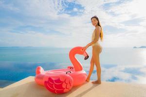 Portrait young asian woman on flamingo flotteur gonflable autour de la piscine extérieure de l'hôtel resort photo