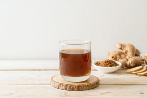 verre de jus de gingembre chaud et sucré aux racines de gingembre - style de boisson saine photo