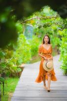 portrait belle jeune femme asiatique marcher sur le chemin marcher dans le jardin photo