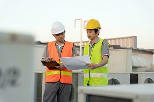 l'équipe d'ingénieurs utilise un ordinateur portable et vérifie le plan sur place. l'entrepreneur et l'inspecteur inspectent la construction pendant le projet.le forman civil vérifie l'assurance qualité. auditer, inspecter, contrôler la qualité. photo