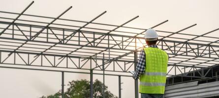 inspecteur ou ingénieur est inspecter construction et qualité assurance Nouveau usine en utilisant une liste de contrôle. ingénieurs ou architectes ou contacteur travail à construire le usine avant remise il plus de à le Accueil photo