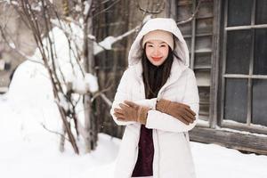 belle jeune femme asiatique souriante heureuse de voyager en hiver neige