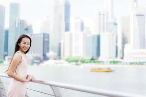 belle femme asiatique souriante et heureuse de voyager dans la ville de singapour photo