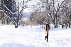 portrait jeune belle femme asiatique sourire joyeux voyage et profiter de la neige hiver photo