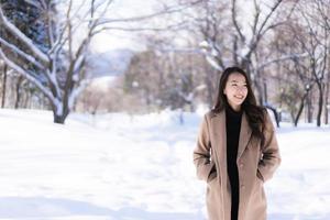 portrait jeune belle femme asiatique sourire joyeux voyage et profiter de la neige hiver photo