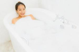 Portrait belle jeune femme asiatique prendre une baignoire dans la salle de bain photo