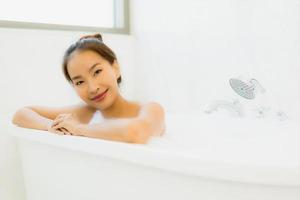 Portrait belle jeune femme asiatique prendre une baignoire dans la salle de bain photo