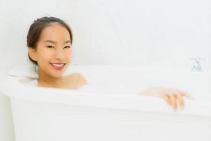 Portrait belle jeune femme asiatique prendre une baignoire dans la salle de bain photo