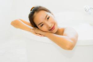 Portrait belle jeune femme asiatique prendre une baignoire dans la salle de bain photo