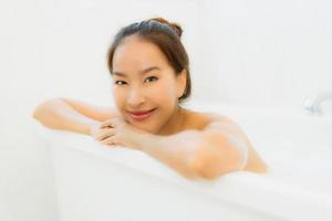 Portrait belle jeune femme asiatique prendre une baignoire dans la salle de bain photo