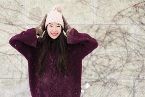 belle jeune femme asiatique souriante heureuse de voyager en hiver neige photo