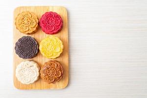 Gâteau de lune chinois coloré aux saveurs mélangées sur plaque de bois photo