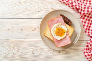 pain maison, fromage grillé, jambon garni et œuf au plat avec saucisse de porc pour le petit-déjeuner photo