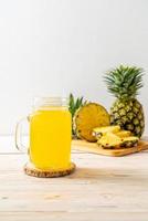 jus d'ananas frais sur fond de bois photo