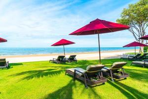chaises de plage et parasols avec fond de plage océan mer photo