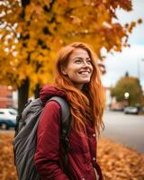 une Jeune femme avec rouge cheveux et une sac à dos est souriant dans le tomber génératif ai photo