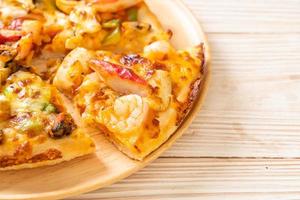 fruits de mer de crevettes, poulpes, moules et pizza au crabe sur plateau en bois photo