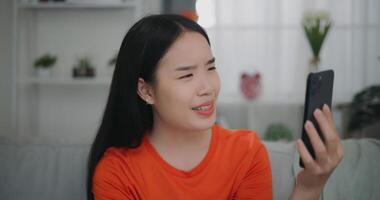 Jeune asiatique femme vidéo appel avec ami sur mobile téléphone photo