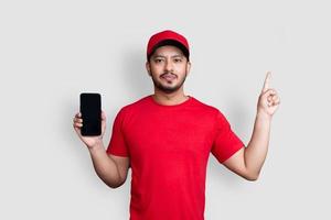 employé de livraison en uniforme de t-shirt blanc bonnet rouge tenir l'application de téléphone mobile noir isolé sur fond blanc photo