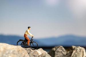 voyageur miniature avec vélo sur le rocher photo