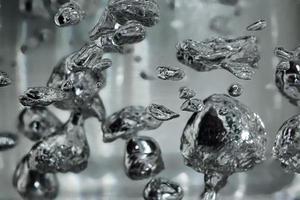 gouttes et bulles de mercure dans l'eau. élément chimique dangereux, l'expérience scientifique. photo