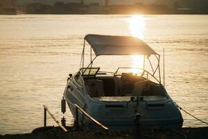 yacht bateau à le jetée, le Matin Soleil brille dans le l'eau photo