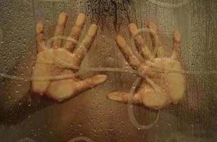 main sur la paroi de la douche photo