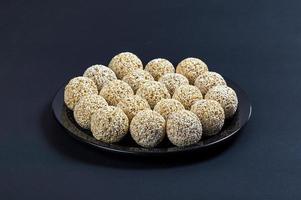 amarante ladoo ou rajgira laddu ou cholai ke laddo en plaque noire sur fond noir. photo