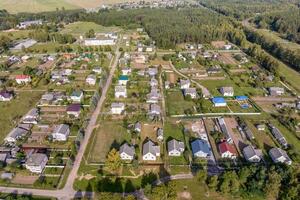 panoramique aérien vue de éco village avec en bois Maisons, gravier route, jardins et vergers photo