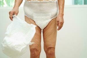 asiatique Sénior femme patient portant adulte incontinence couche tampon dans hôpital. photo