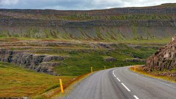 panoramique plus de une pavé route et islandais coloré et sauvage paysage avec fjords à été temps, Ouest Islande photo