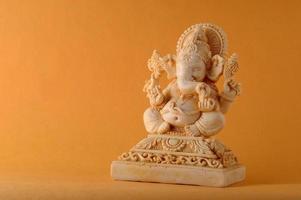 dieu hindou ganesha. idole de ganesha sur fond jaune photo