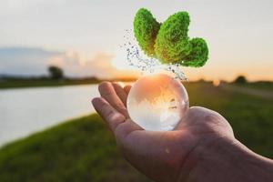 verre globe à portée de main avec le lever du soleil photo