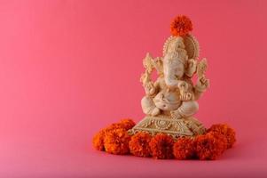 dieu hindou ganesha. idole de ganesha sur fond rose photo