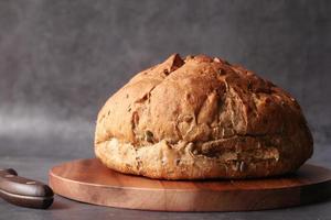 pain rond brun cuit sur planche à découper photo