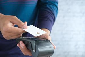 concept de paiement sans contact avec jeune homme payant par carte de crédit photo