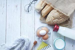 oeufs dans un bol, pain complet et lait sur table photo