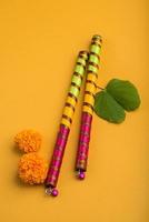 festival indien dussehra et navratri, montrant des fleurs de bauhinia racemosa et de souci avec des bâtons de dandiya. photo