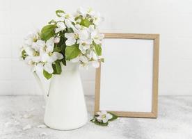 fleur de pommier de printemps dans un vase avec un cadre photo vide